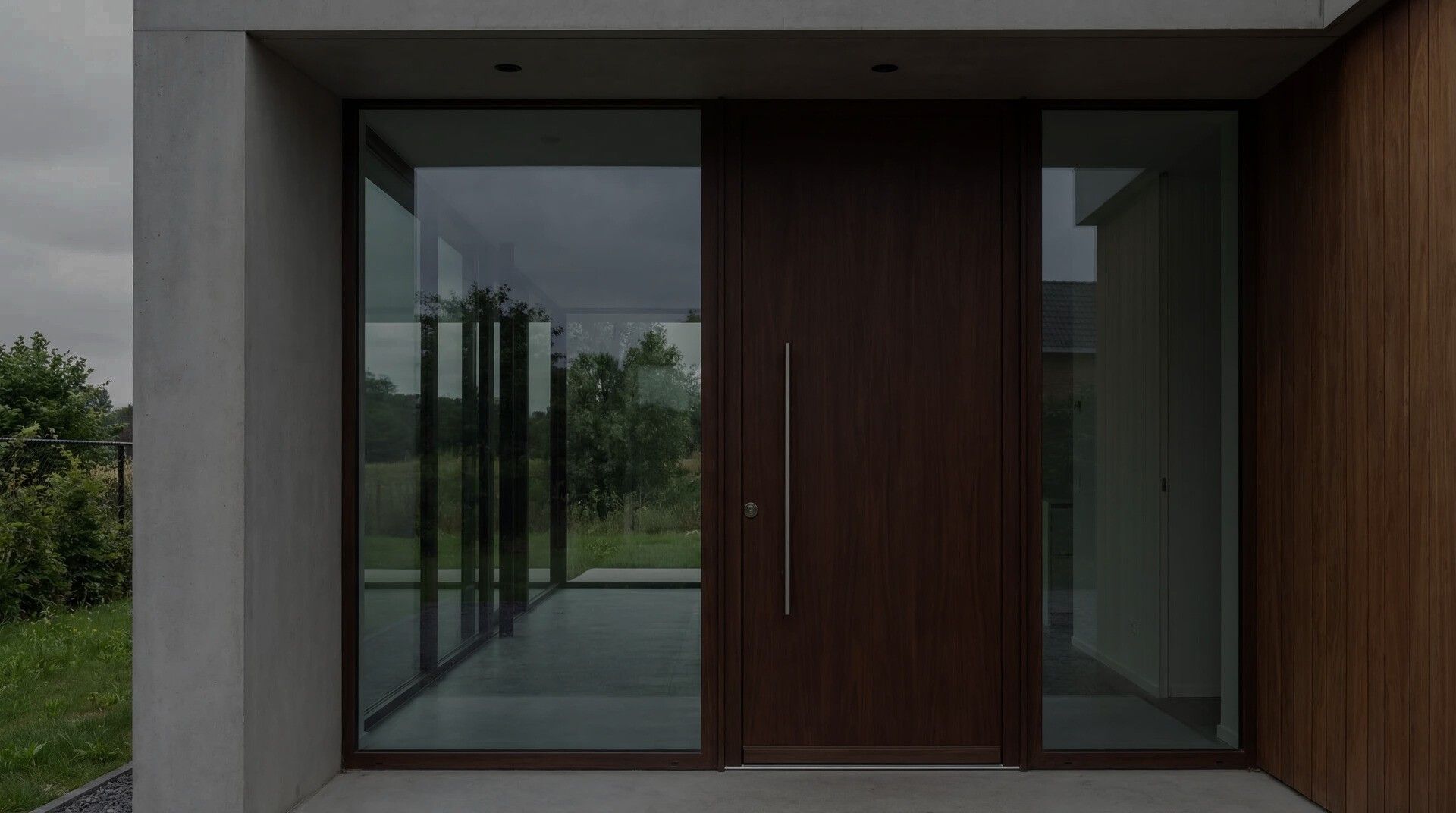 Porte d’entrée en bois et baies vitrées posées dans une maison neuve